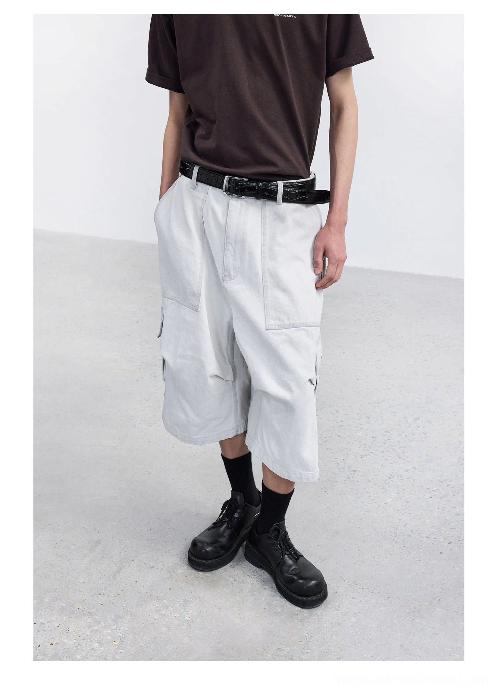 White washed denim wide-leg cargo capri shorts on male model with brown t-shirt leather belt black socks and leather boots front full body streetwear outfit