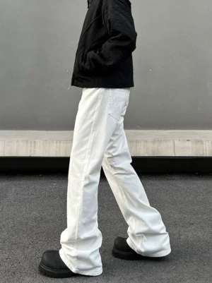 Side view of clean white wide flare jeans showing the relaxed flared leg, side seam, stacked hem, and streetwear styling with black platform shoes