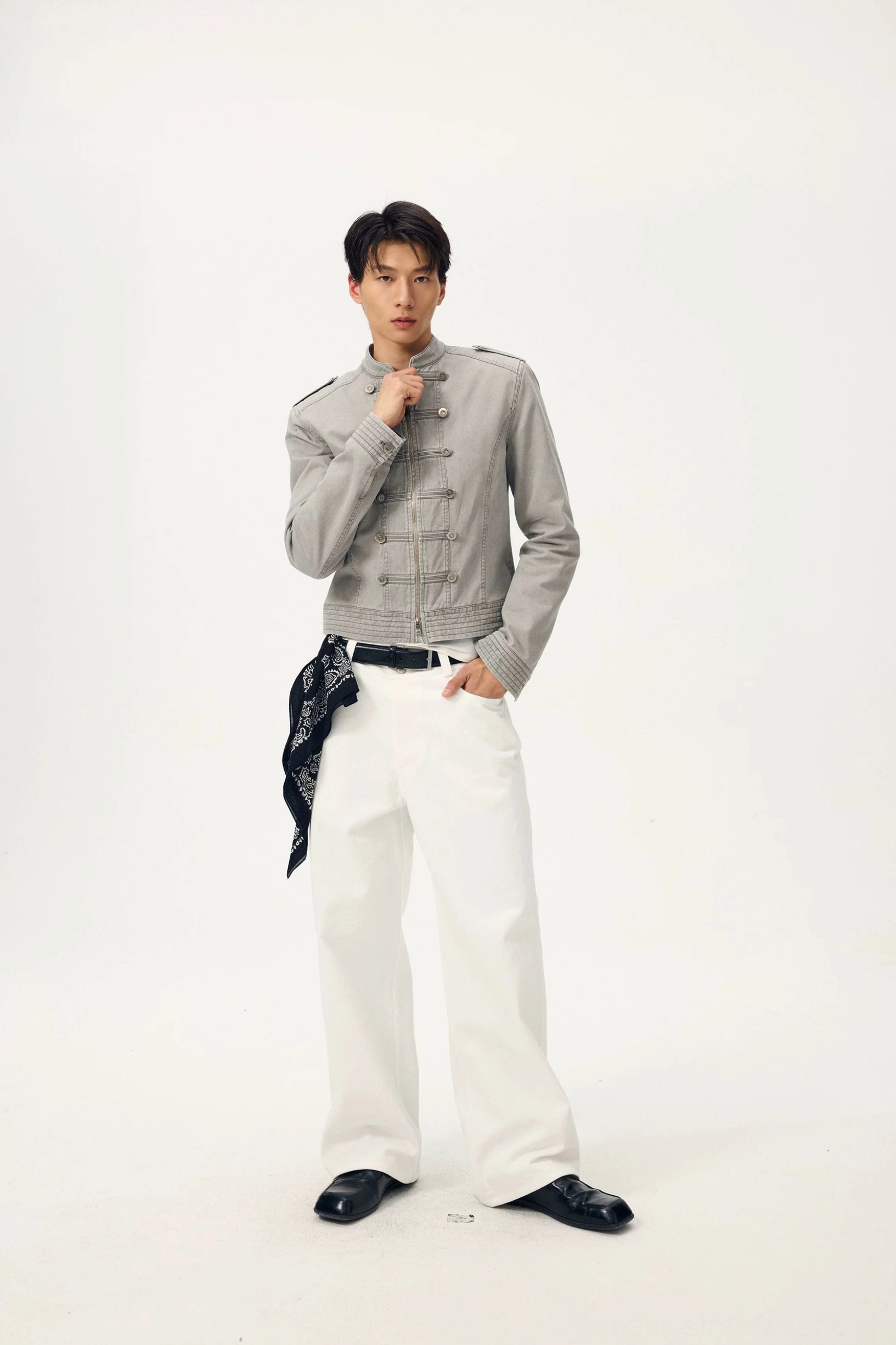White wide-leg denim trousers paired with a heather grey cropped stand-collar military jacket and printed waist bandana