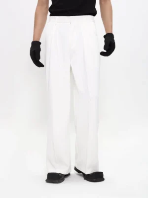 White wide-leg suit trousers on a male model with high waist front pleats smooth drape fabric and relaxed Korean streetwear silhouette