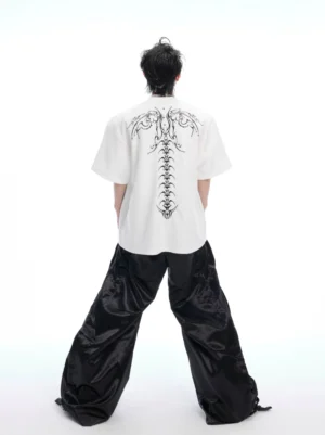 Back view of white oversized Korean punk streetwear t-shirt featuring detailed wing and spine graphic print with relaxed drop shoulder silhouette