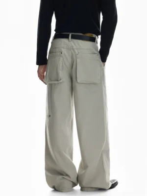 Rear view of light beige wide-leg canvas cargo pants with oversized square back pockets, relaxed Korean streetwear fit, and naturally stacked full-length hem