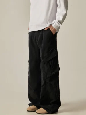 Black wide leg cargo combat pants shown from a left rear three-quarter view with oversized side pockets, white long-sleeve top, and beige loafers