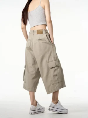 Back view of khaki cropped wide-leg cargo shorts showing rear waistband, leather waist patch, and spacious side pockets