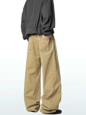 Khaki wide-leg cotton cargo trousers shown from a rear three-quarter angle on a male model in a relaxed Korean streetwear outfit, featuring a loose fit and back patch pocket