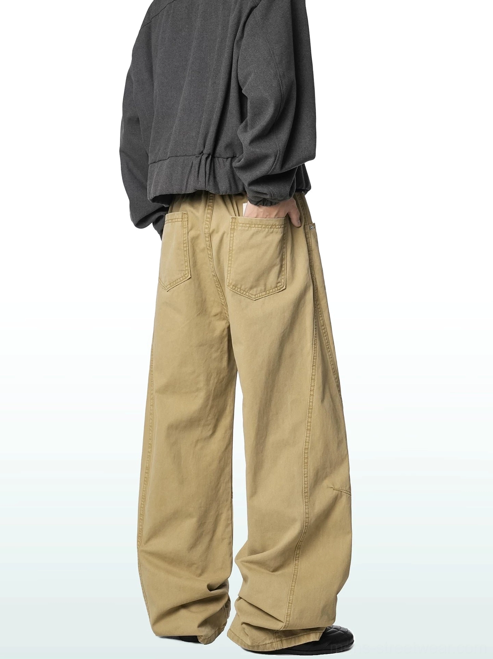 Khaki wide-leg cotton cargo trousers shown from a rear three-quarter angle on a male model in a relaxed Korean streetwear outfit, featuring a loose fit and back patch pocket