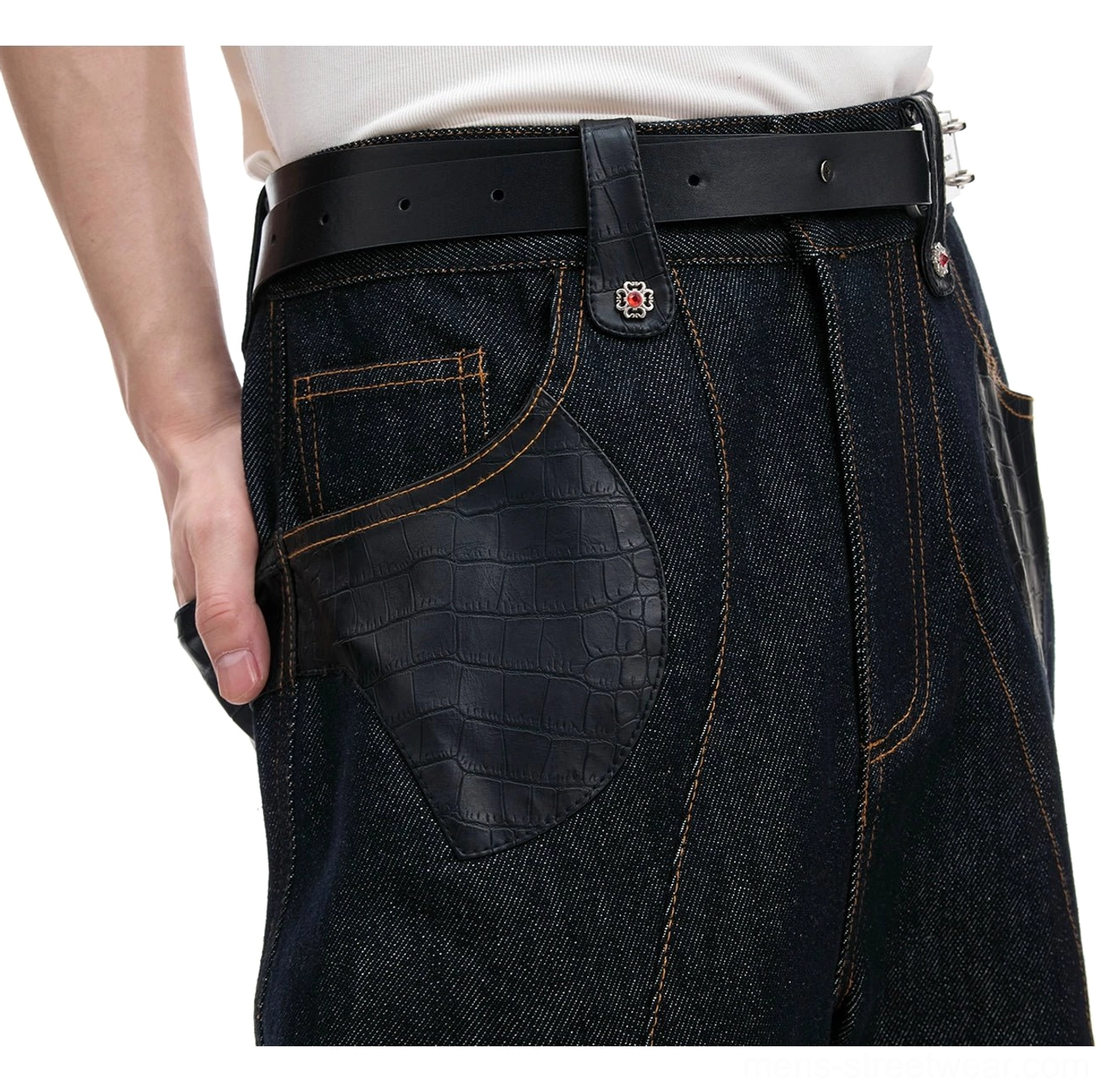 Close-up of wide-leg dark denim jeans showing the waist, black leather belt with metal hardware, crocodile-textured pocket patch, and contrast topstitching