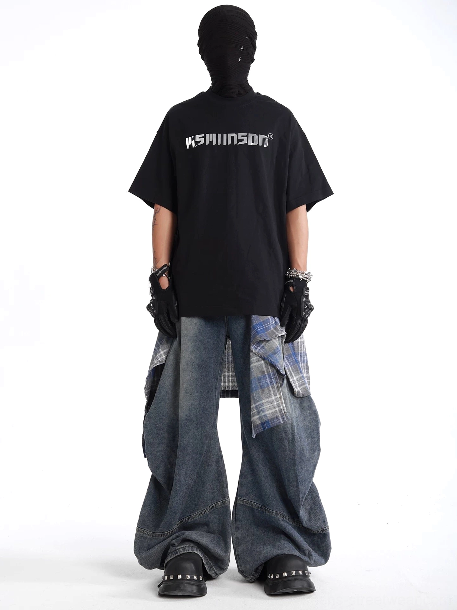 Wide leg denim jeans styled with graphic T-shirt, gloves, and face covering in a contemporary punk inspired streetwear outfit