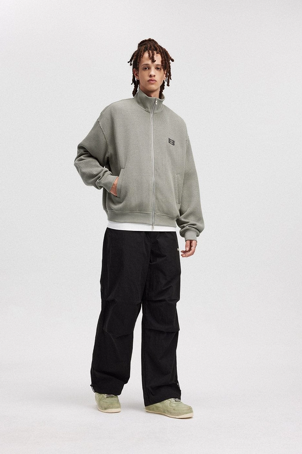 Full front outfit view featuring relaxed wide-leg drawstring track pants styled with a ribbed zip jacket and sneakers