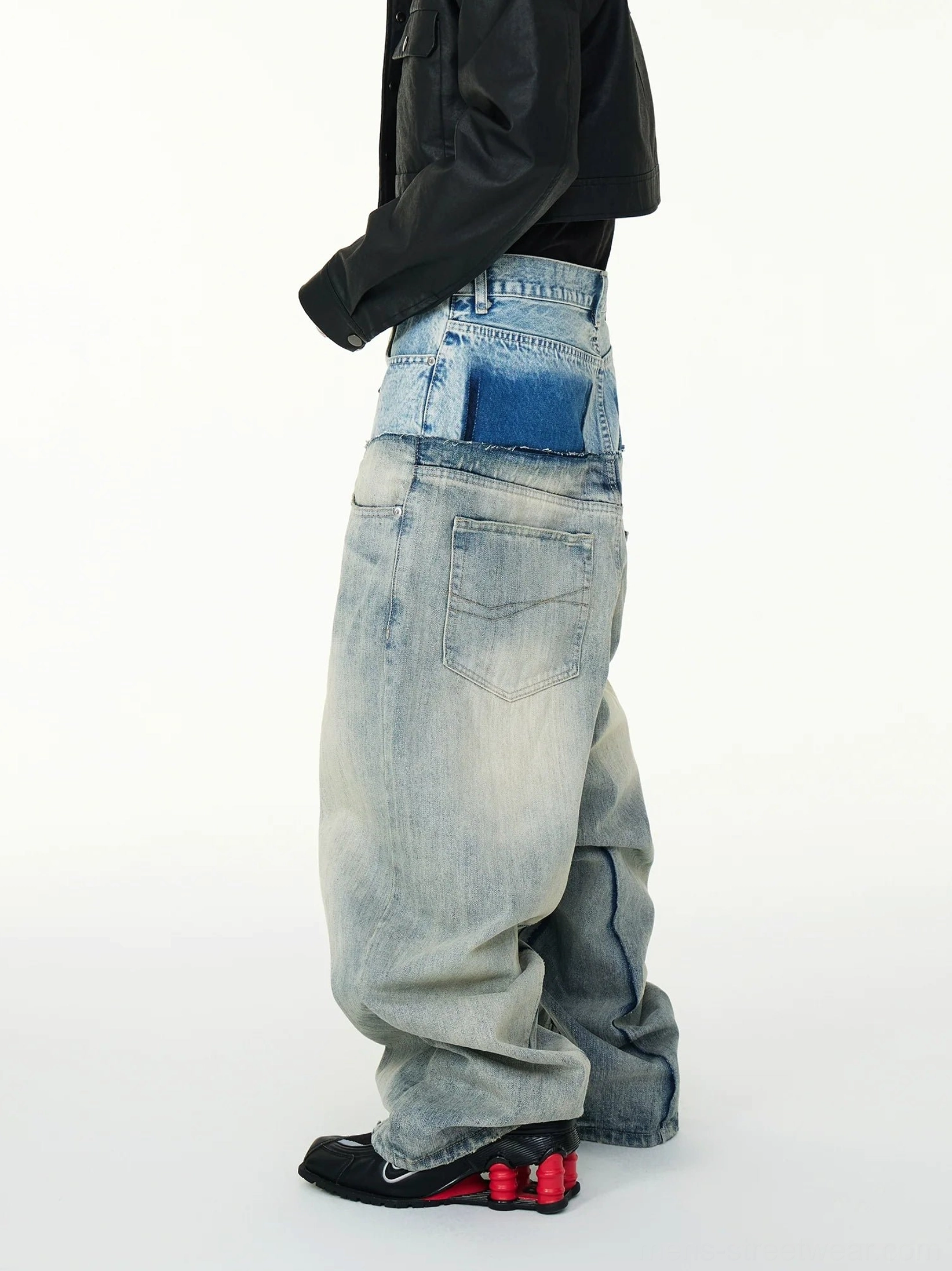 Right side view of wide leg layered waistband jeans in washed blue denim styled with black sneakers for a Korean streetwear outfit