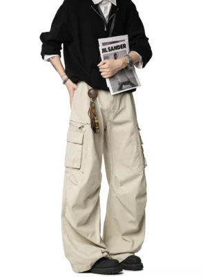 Beige wide-leg cargo pants styled on a male model in a studio streetwear fashion shoot with multiple utility pockets