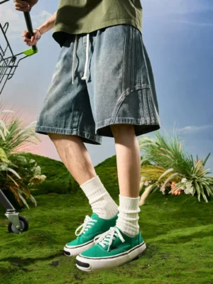 Wide-leg washed denim shorts with adjustable drawstring waistband and multi-piece curved stitching in a relaxed streetwear silhouette