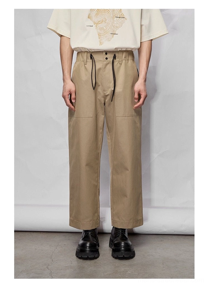 Front detail of khaki wide-leg cropped streetwear pants with adjustable drawstring waist and relaxed straight silhouette