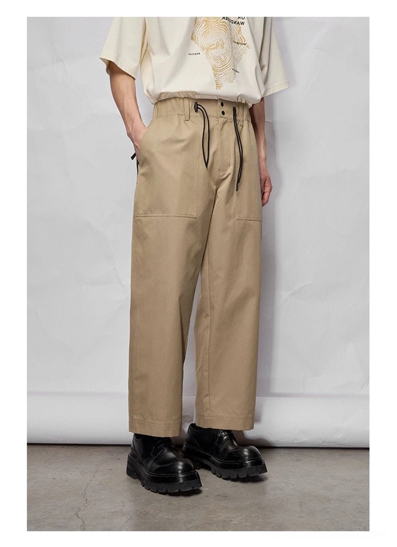 Right-side view of khaki wide relaxed cropped streetwear pants styled with a white graphic oversized tee