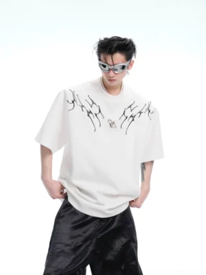 Front view of off white wing spine graphic oversized streetwear tee with thorn inspired chest print and drop shoulder fit styled with black wide leg pants