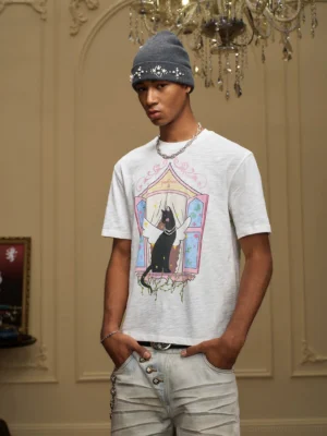 Male model wearing an off white winged cat stained glass graphic T-shirt in a vintage European interior