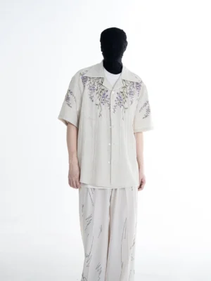 Front full-body view of a light gray wisteria embroidered camp shirt with purple floral detailing, relaxed Korean streetwear fit, short sleeves, and open collar