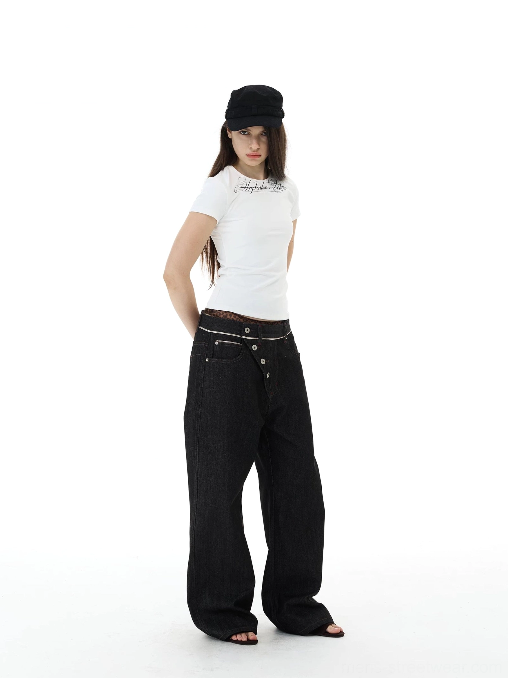 Female model wearing high-rise inspired asymmetric button fly black wide-leg jeans with a relaxed avant-garde silhouette