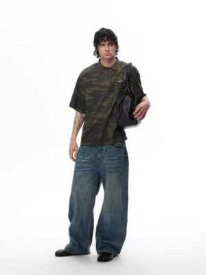 Full body model wearing a relaxed camouflage polo shirt with black leather shoulder bag and casual streetwear accessories