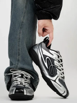 Black and silver futuristic retro runner sneakers with breathable mesh upper metallic overlays and wave side detailing styled with baggy blue jeans