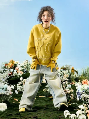 Yellow oversized crewneck sweatshirt with raised abstract embroidery, dropped shoulders, long sleeves, and wide-leg streetwear styling