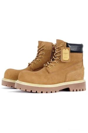 Yellow brown nubuck leather classic work boots with golden metal eyelets, leather hang tag, thick sawtooth rubber lug soles, and rugged streetwear styling on a white background