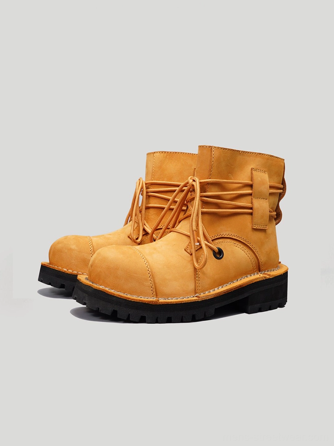 Pair of yellow two-tone leather utility ankle boots front three-quarter view with black treaded lug outsoles
