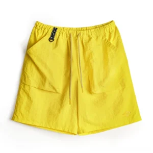 Bright yellow water-repellent Taslon cargo shorts with crinkled technical fabric, elastic drawstring waist, oversized flap pockets, utility waist detail, and subtle lower hem mark